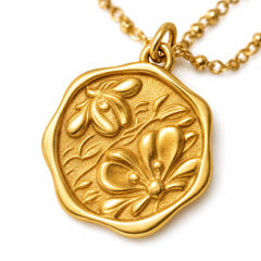 AYNOHA gold floral medallion necklace on white - close-up detail
